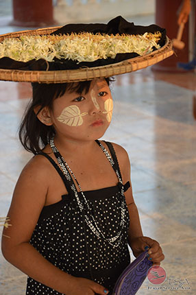 Kind mit Blütenkorb auf dem Kopf